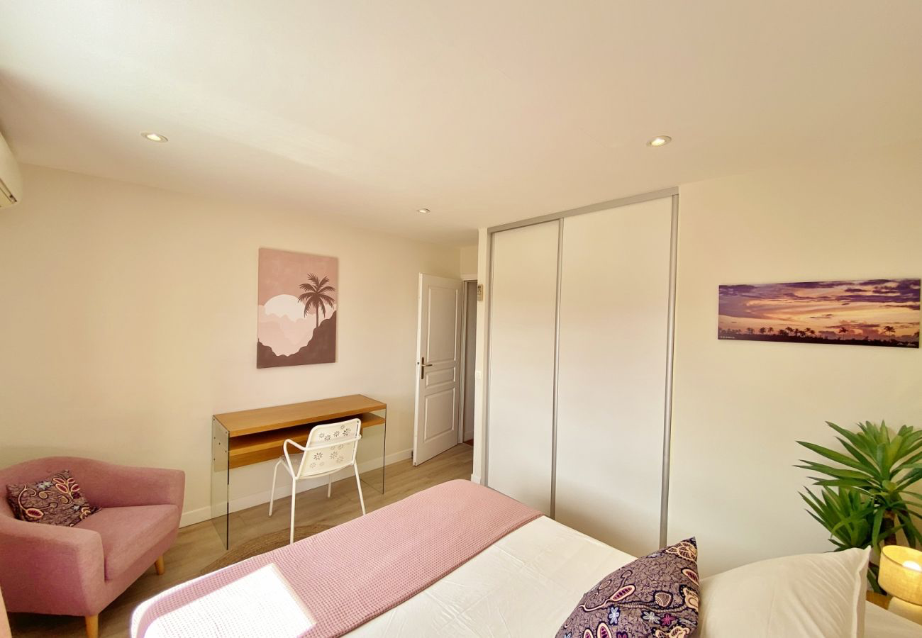 Chambre de la Villa Palmazur avec coin bureau, fauteuil et grands placards